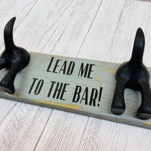 Load image into Gallery viewer, wooden plaque with two dog lead hooks and the text lead me to the bar