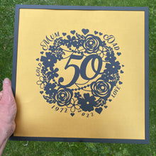 Load image into Gallery viewer, black floral wreath image with 50 in the middle and a gold background with wedding anniversary details around the wreath in black frame
