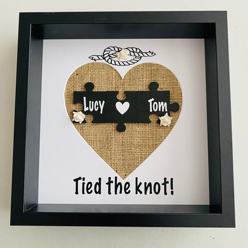 framed wedding gift with names on jigsaw pieces cream roses and tied the knot text