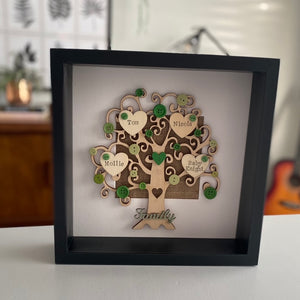 wooden family tree with names on hearts and coloured buttons in a frame