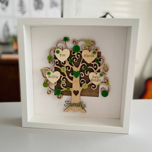 wooden family tree with names on hearts and coloured buttons in a frame