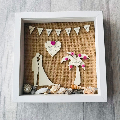 beach themed wedding frame with palm tree, bride and groom figures and shells