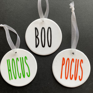 white bauble with black string and the word boo, hocus or pocus