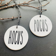 Load image into Gallery viewer, white bauble with black string and the word hocus or pocus
