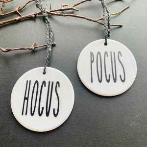 white bauble with black string and the word hocus or pocus