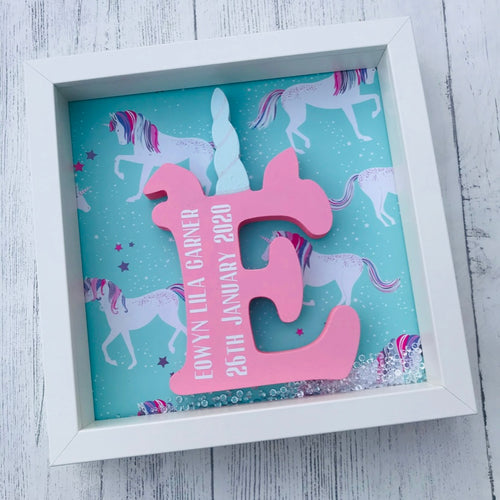 personalised child's initial with a unicorn horn on a unicorn background in a frame