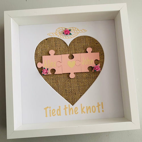 framed wedding gift with names on jigsaw pieces pink roses and tied the knot text