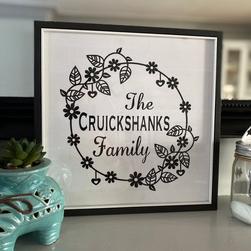 black framed family name in wreath wall art in black and white